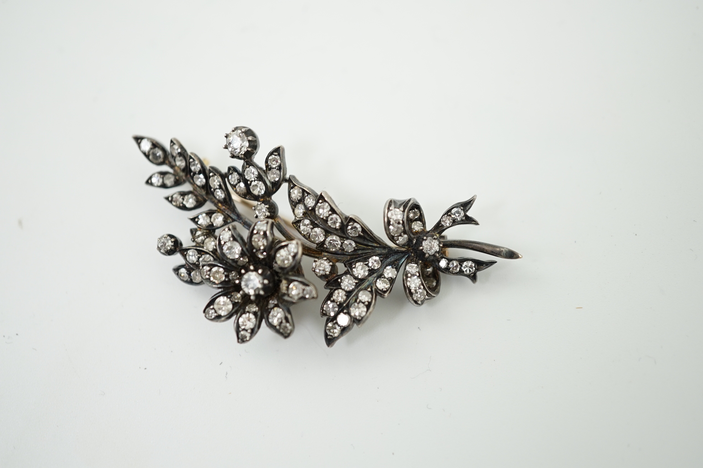 A late Victorian gold, silver and diamond cluster set trembleuse floral spray brooch